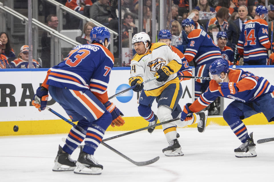 Nashville Predators' Kiefer Sherwood (44) shoots under pressure from Edmonton Oilers' Vincent Desharnais (73) and Warren Foegele (37) during third-period NHL hockey game action in Edmonton, Alberta, Saturday, Jan. 27, 2024. (Amber Bracken/The Canadian Press via AP)