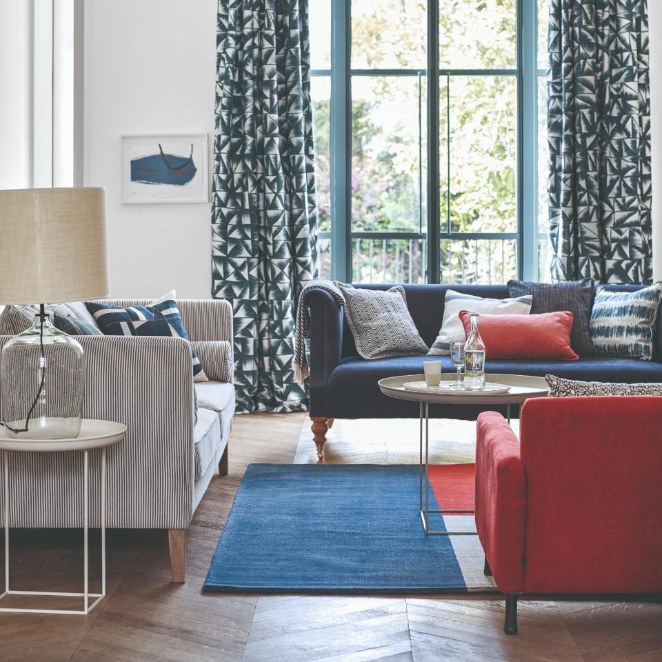 A living room with a contrasting red sofa