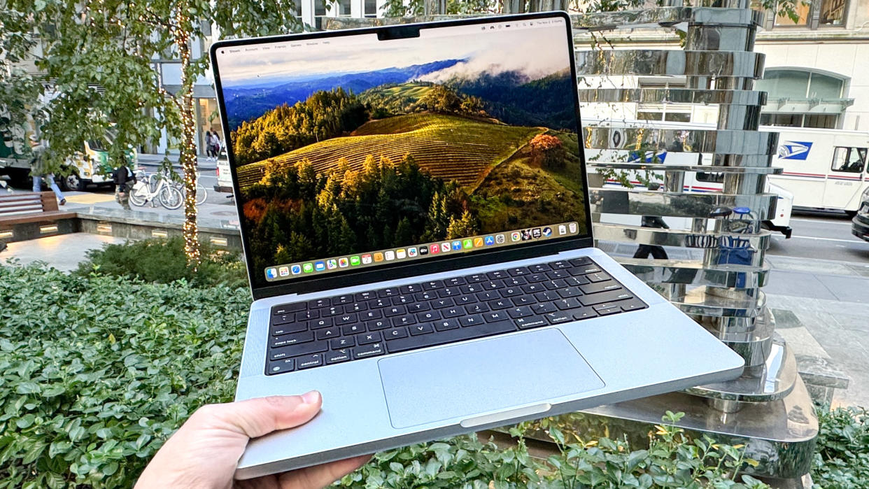  MacBook Pro 14-inch M3 holding in air open . 