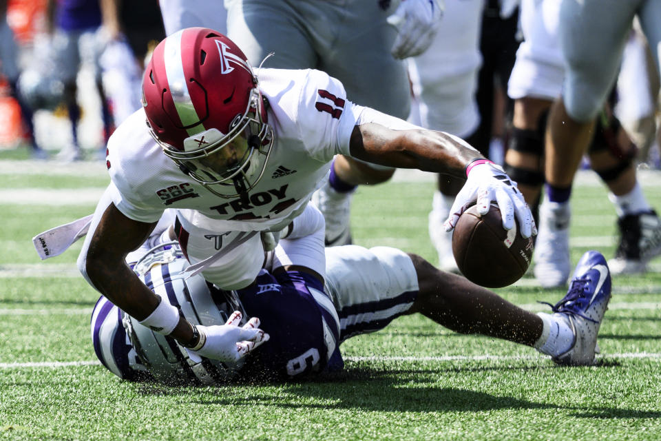 Troy wide receiver Deshon Stoudemire (11) stretches for yardage while being tackled by Kansas State cornerback Donovan McIntosh (9) during the first half of an NCAA college football game in Manhattan, Kan., Saturday, Sept. 9, 2023. (AP Photo/Reed Hoffmann)