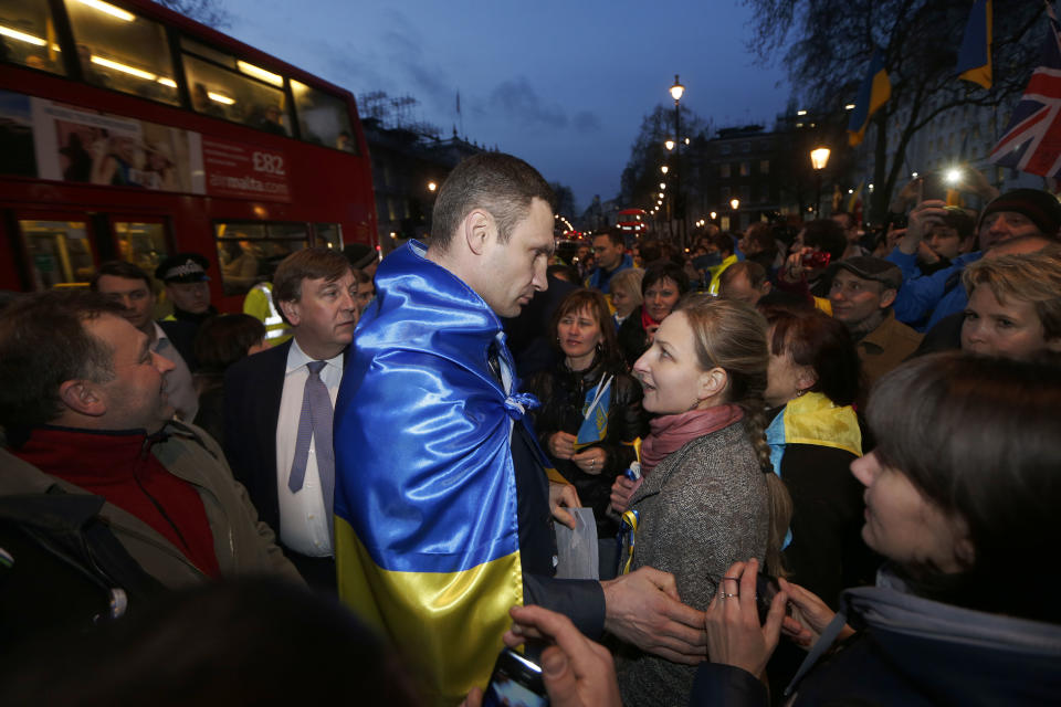 Ukraine's MP Vitali Klitschko, leader of the UDAR (Ukrainian Democratic Alliance for Reform) party, centre left, speaks to a protester outside 10 Downing Street in London after a meeting with British Prime Minister David Cameron and Foreign Secretary William Hague, Wednesday, March 26, 2014. (AP Photo/Sang Tan)