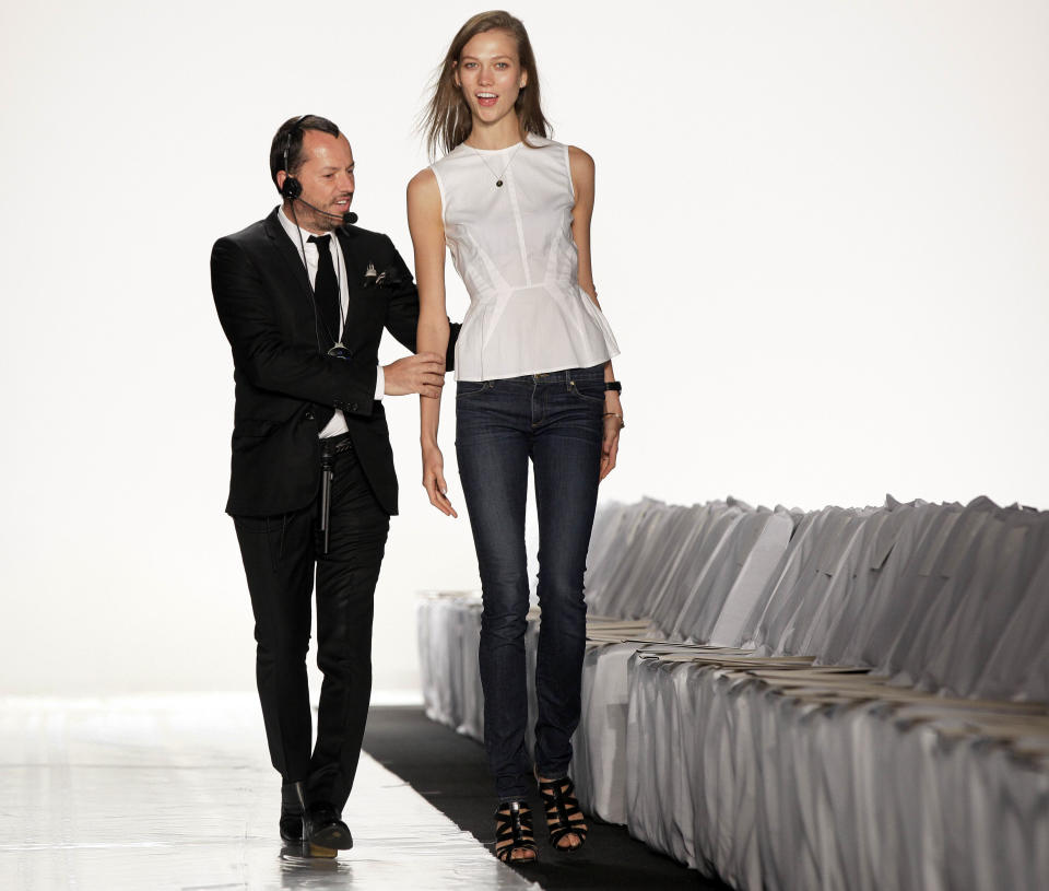 Fashion show producer Alex Betak, Director of Bureau Betak, schools model Karly Kloss on the runway before the Michael Kors Spring 2013 collection is modeled, during Fashion Week in New York, Wednesday, Sept. 12, 2012. (AP Photo/Richard Drew)