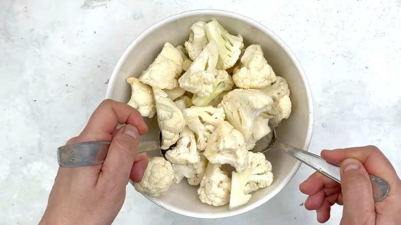 tossing cauliflower in oil