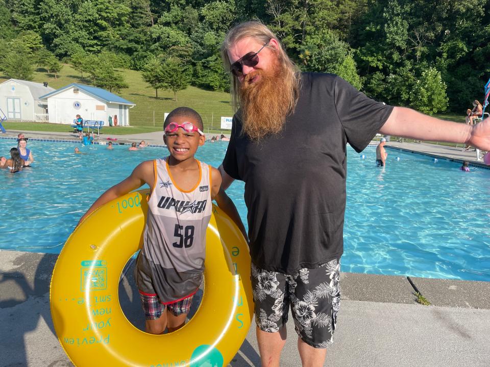 Travis Burnett, Children’s Director for Beaver Ridge United Methodist Church, and his son Teddy Burnett, 8, welcome the community to the pool party at Karns Lions Club Community Pool Saturday, July 16, 2022.