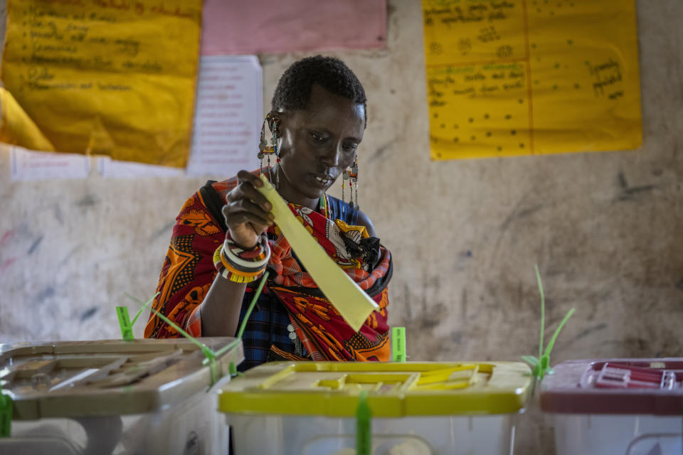 A Maasai woman casts her vote at a polling station in Esonorua Primary School, in Kajiado County, Kenya Tuesday, Aug. 9, 2022. Polls opened Tuesday in Kenya's unusual presidential election, where a longtime opposition leader who is backed by the outgoing president faces the deputy president who styles himself as the outsider. (AP Photo/Ben Curtis)