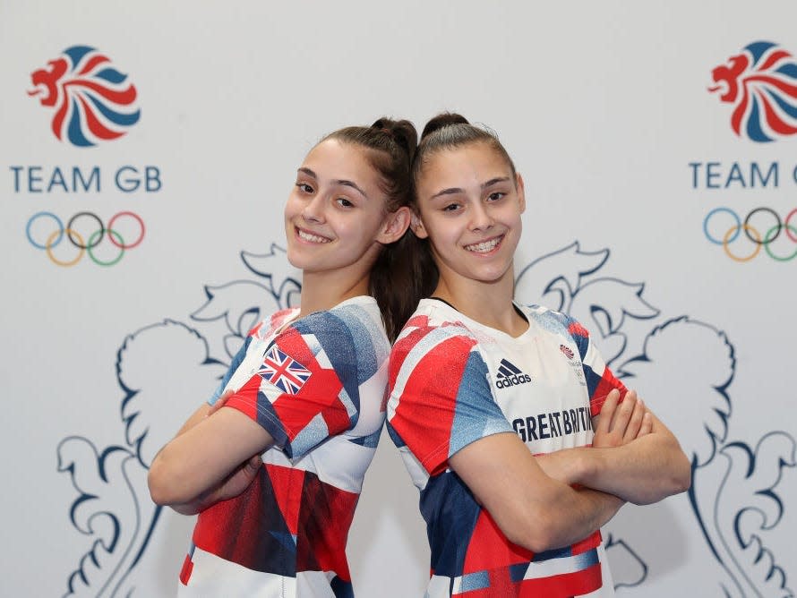Jennifer and Jessica Gadirova stand back to back, arms crossed