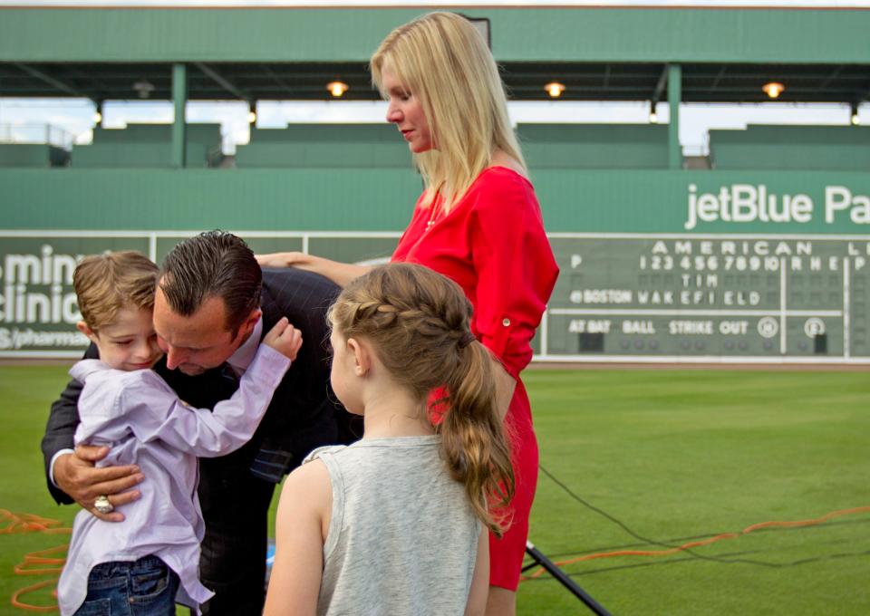 FILE - Boston Red Sox pitcher Tim Wakefield, center left, hugs his son, Trevor, 7, as his wife, Stacy, right, and daughter, Brianna, 6, look on after Wakefield announced his retirement from baseball during a news conference, Friday, Feb. 17, 2012, in Fort Myers, Fla. Stacy Wakefield, the widow of former Boston Red Sox pitcher and two-time World Series champion Tim Wakefield, has died. Wakefield's family said in a statement released through the Red Sox that she died Wednesday, Feb. 28, 2024 at her Massachusetts home, less than five months after her husband died at the age of 57. (AP Photo/David Goldman, File)