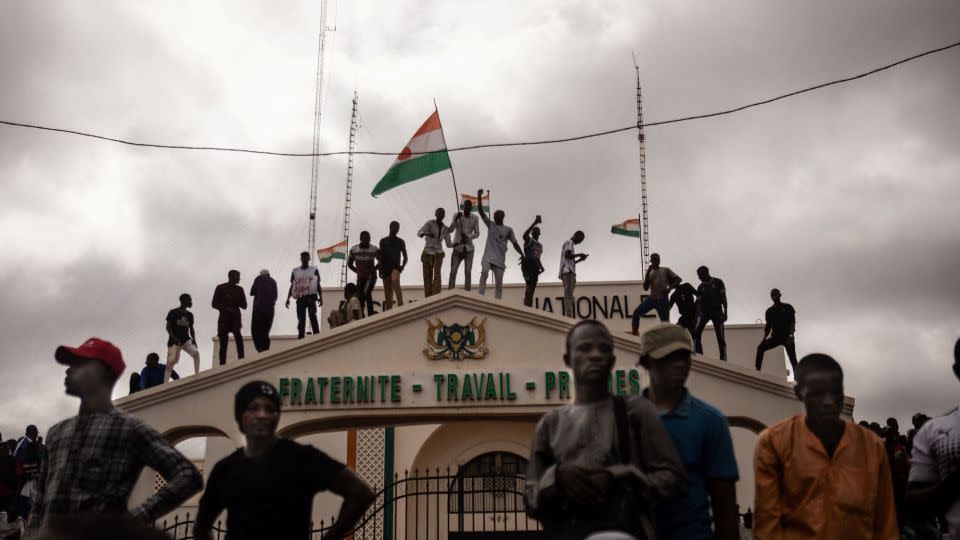 Pro-coup protesters hold the Nigerien flag during a demonstration on independence day in Niamey on August 3, 2023.  - Stringer/AFP/Getty Images