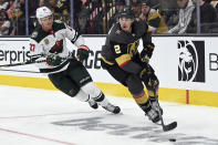 Minnesota Wild center Nick Bjugstad (27) and Vegas Golden Knights defenseman Zach Whitecloud (2) battle for the puck during the third period of Game 1 of a first-round NHL hockey playoff series Sunday, May 16, 2021, in Las Vegas. (AP Photo/David Becker)