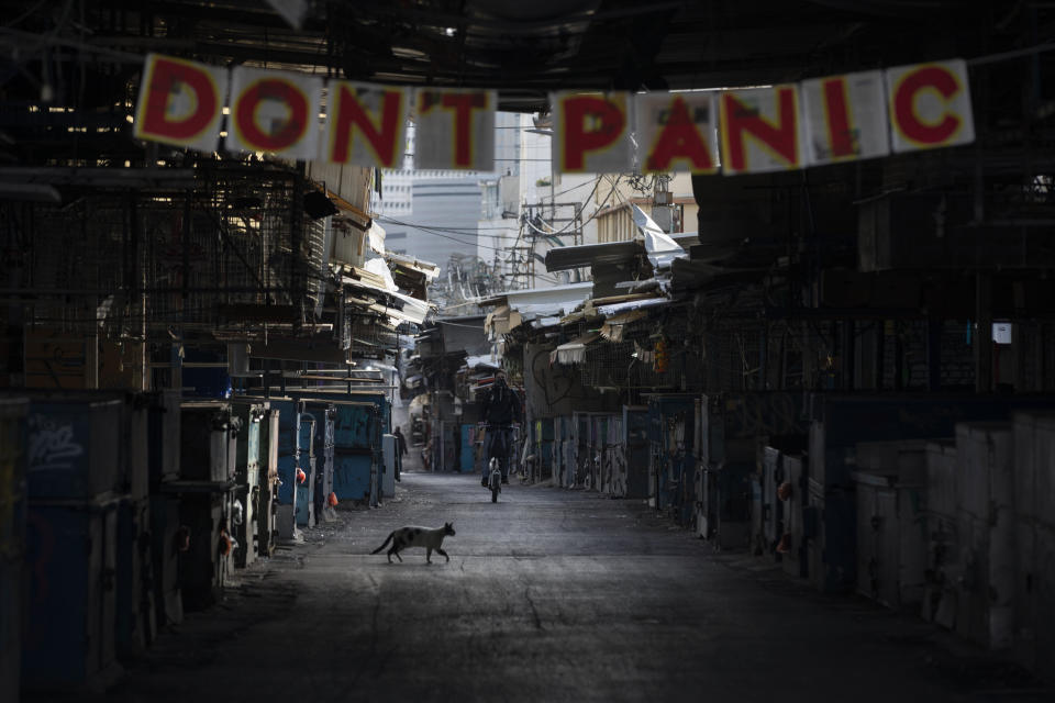 A "don't panic" sign hang on the entrance of a closed food market that was shut down in order to reduce the spread of the coronavirus, in Tel Aviv, Israel, Monday, March 23, 2020. In Israel daily life has largely shut down with coronavirus cases multiplying greatly over the past week. (AP Photo/Oded Balilty)