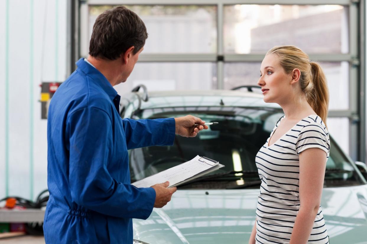 Mechanic discussing car with young woman