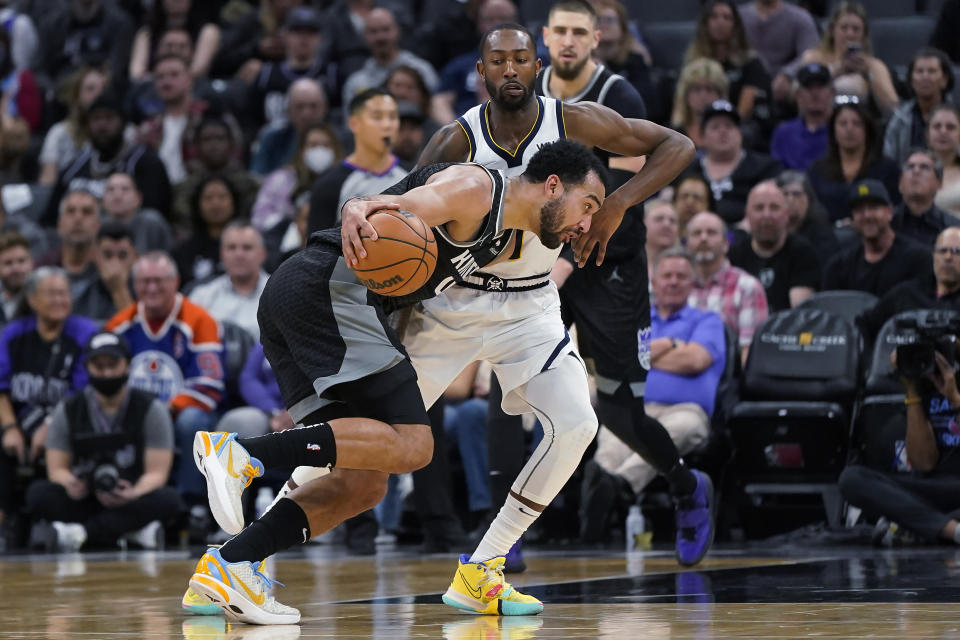 Sacramento Kings forward Trey Lyles drives to the basket against Denver Nuggets guard Davon Reed during the first half of an NBA basketball game in Sacramento, Calif., Wednesday, March 9, 2022. (AP Photo/Jeff Chiu)