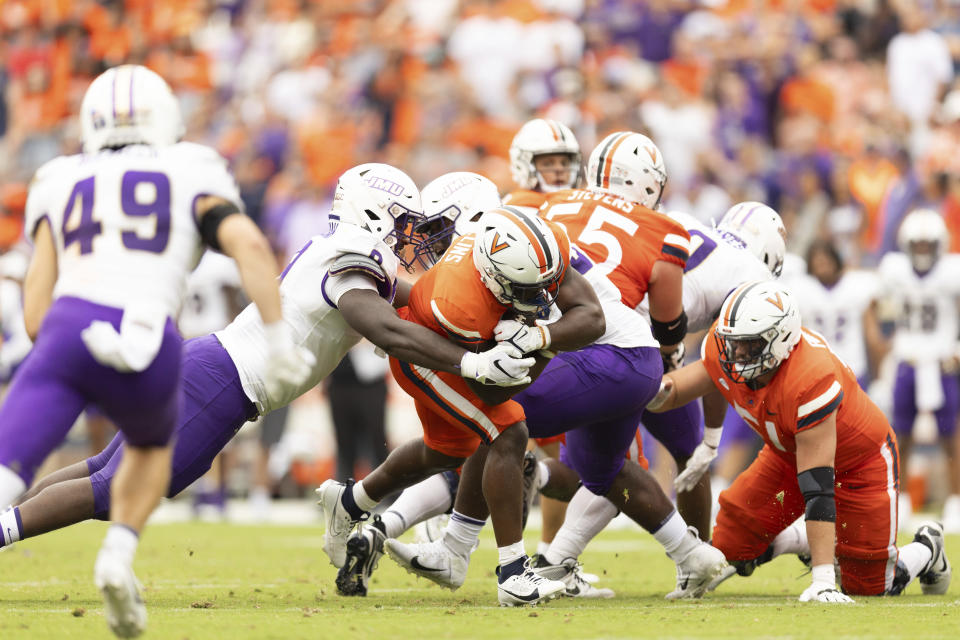 Virginia's Mike Hollins (7) is tackled during an NCAA college football game against James Madison in Charlottesville, Va., on Saturday, Sept. 9, 2023. (AP Photo/Mike Kropf)