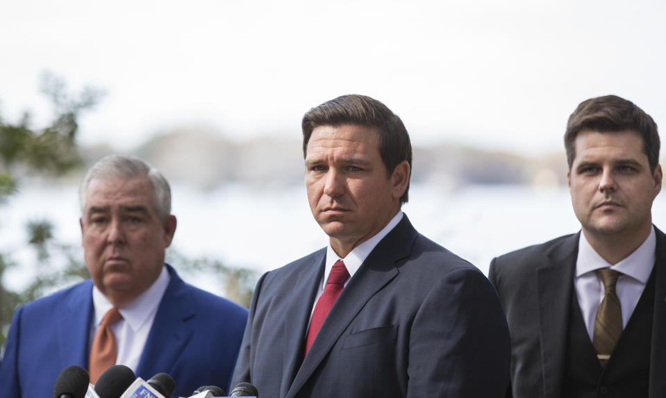 FILE - In this Jan. 17, 2019, file photo Florida Gov. Ron DeSantis, center, John Morgan, left, and Rep. Matt Gaetz, right, listen during a press conference at Kraft Azalea Garden in Winter Park, Fla. (Willie J. Allen Jr./Tampa Bay Times via AP, File)