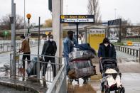 Varios viajeros cargan sus maletas en el aeropuerto de Manchester. Reino Unido está sufriendo la virulencia de la nueva cepa del coronavirus. (Photo by OLI SCARFF/AFP via Getty Images)