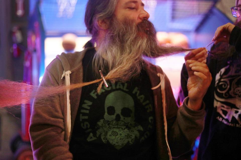 Jimmy Preston, one of the lead organizers of the National Beard and Moustache Championships, gets his beard clipped to another man's beard, Friday, Nov. 11, 2022, at The Gaslight Social in Casper, Wyo.