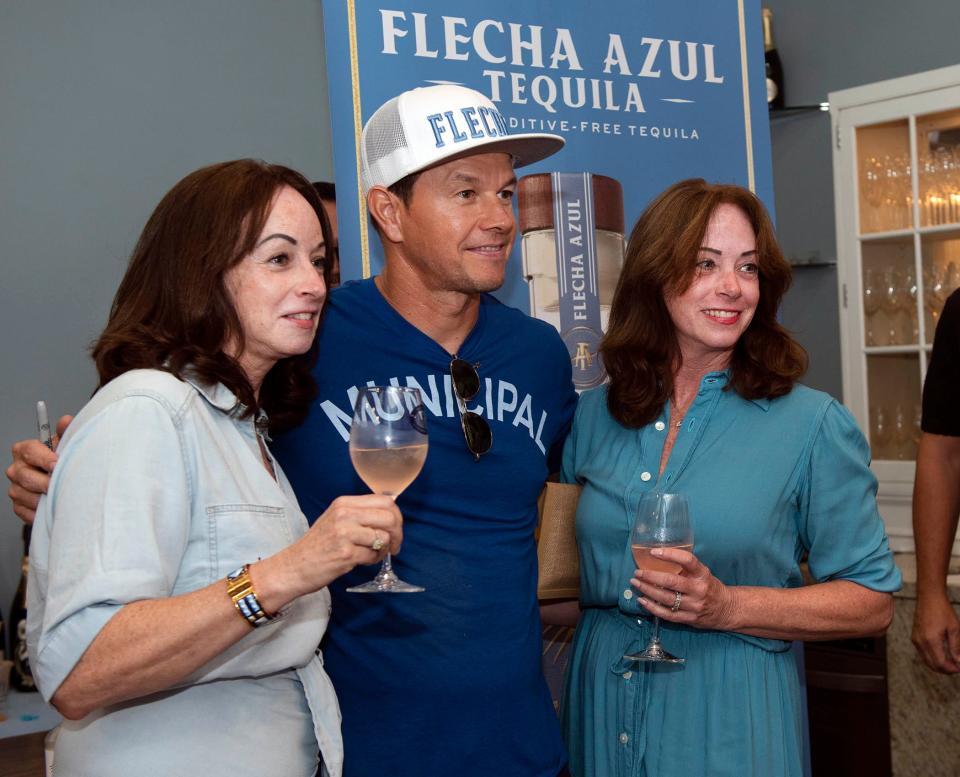 Virginia Philip, left, and Veronica Bauer, right,  pose for a photo with Mark Wahlberg during a bottle-signing event for Flecha Azul Tequila at Virginia Philip Wine and Spirits Shop in Royal Poinciana Plaza August 25, 2023 in Palm Beach. 