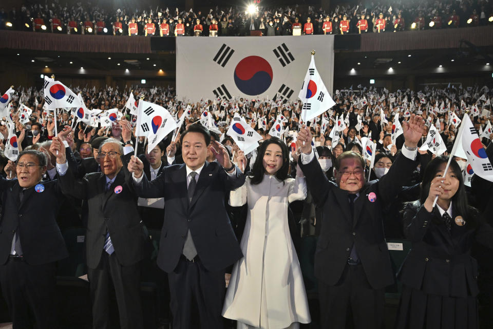 South Korea's President Yoon Suk Yeol, center left, and his wife Kim Keon Hee, center right, give three cheers during a ceremony of the 104th anniversary of the March 1st Independence Movement Day against Japanese colonial rule, in Seoul Wednesday, March 1, 2023. (Jung Yeon-je/Pool Photo via AP)
