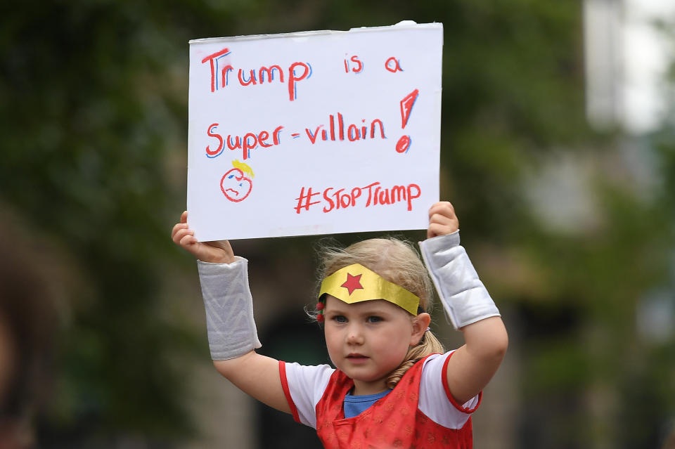 A young demonstrator holds a banner&nbsp;calling U.S. President Donald Trump "a super-villain."