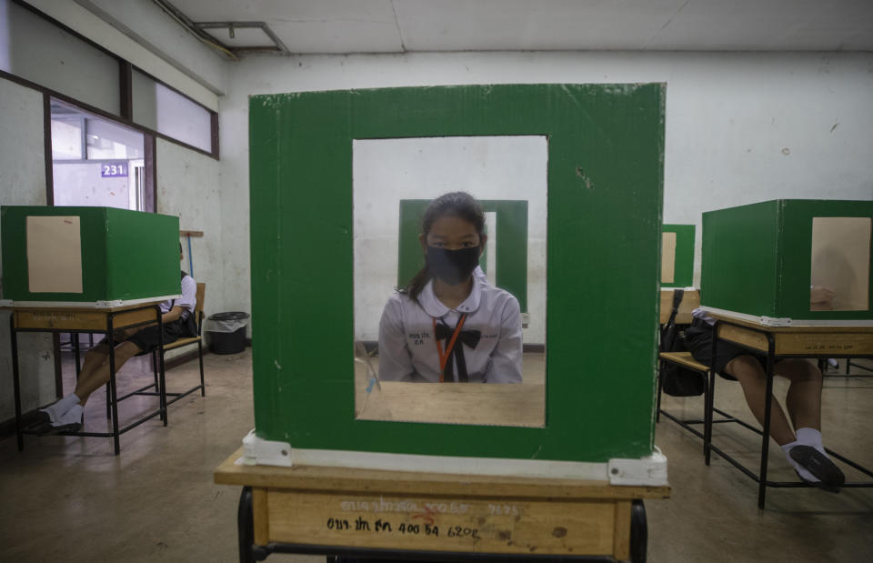 A student sits at her partitioned desk in a classroom at the Samkhok School in Pathum Thani, outside Bangkok, Wednesday, July 1, 2020. Thailand has begun a fifth phase of relaxations of COVID-19 restrictions, allowing the reopening of schools and high-risk entertainment venues such as pubs and massage parlors that had been shut since mid-March. (AP Photo/Sakchai Lalit)