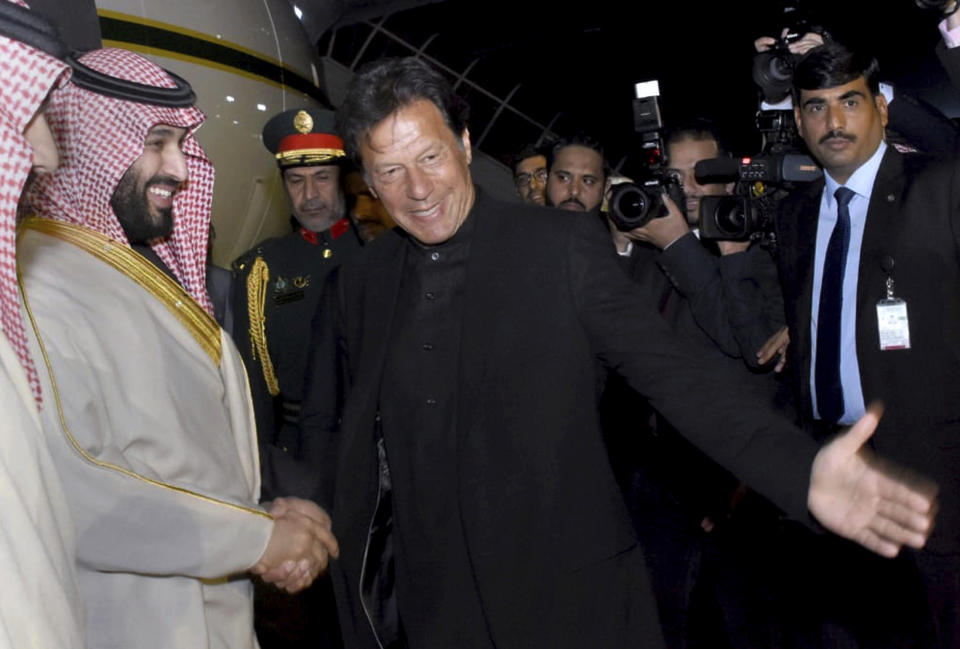 In this photo released by the Press Information Department, Pakistani Prime Minister Imran Khan, centre, greets Saudi Arabia's Crown Prince Mohammed bin Salman, left, upon his arrival at Nur Khan airbase in Rawalpindi, Pakistan, Sunday, Feb. 17, 2019. Saudi Arabia's powerful Crown Prince Mohammed bin Salman began his four-day regional visit on Sunday, arriving in Pakistan where he is widely expected to sign agreements worth billions of dollars to help the Islamic nation overcome its financial crisis. (Press Information Department, via AP)