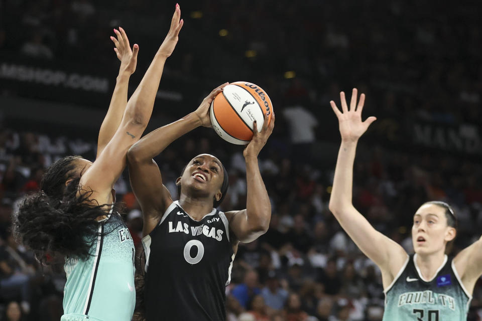 Las Vegas Aces guard Jackie Young (0) shoots over New York Liberty forward Betnijah Laney-Hamilton (44) during the first half of a WNBA Semifinal basketball game, Sunday, Oct. 6, 2024, in Las Vegas. (AP Photo/Ian Maule)