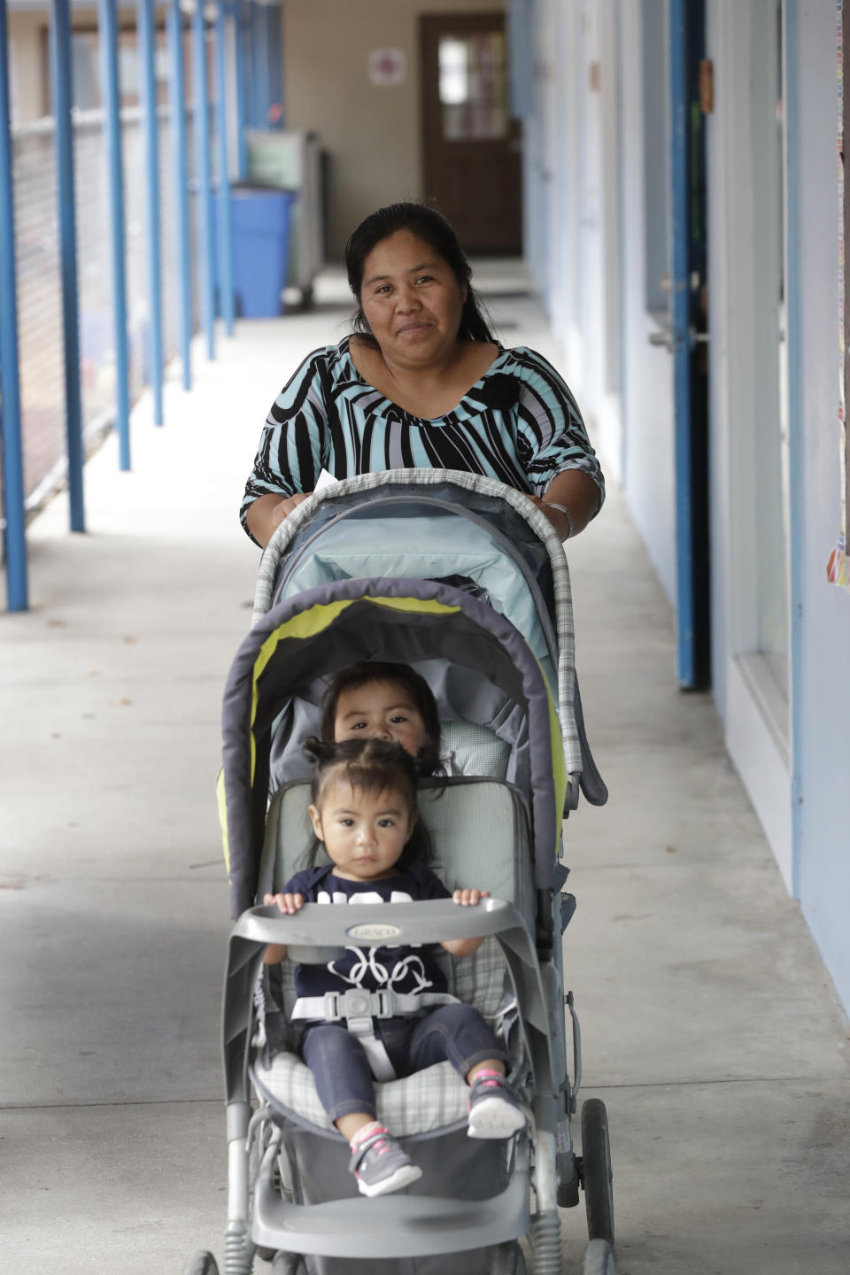 In this, Wednesday, Feb. 12, 2020 photo, Maria Juarez, a Guatemalan mother of three from San Marcos who works picking tomatoes, picks up one of her children and the child of another worker at the Redlands Christian Migrant Association's Rollason Child Development Center in Immokalee, Fla. Small, poor and largely Latino communities around the U.S. historically have been undercounted, an analysis by The Associated Press shows, posing challenges for Census workers in a tally that's supposed to ensure federal dollars get to communities needing them most. (AP Photo/Wilfredo Lee)