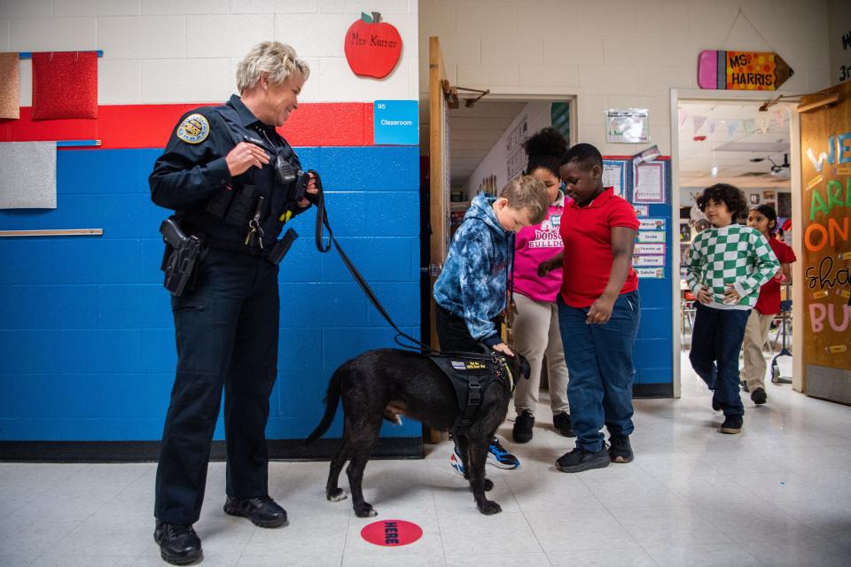 Miles Hollenbeck, pets Sgt. Bo as Graham Megabit waits his turn with Abigail Swindle while Mileck Calderon walks out of his classroom to greet Officer Faye Okert and Sgt. Bo at Dodson Elementary in Hermitage, Tenn., Tuesday, Jan. 9, 2024.