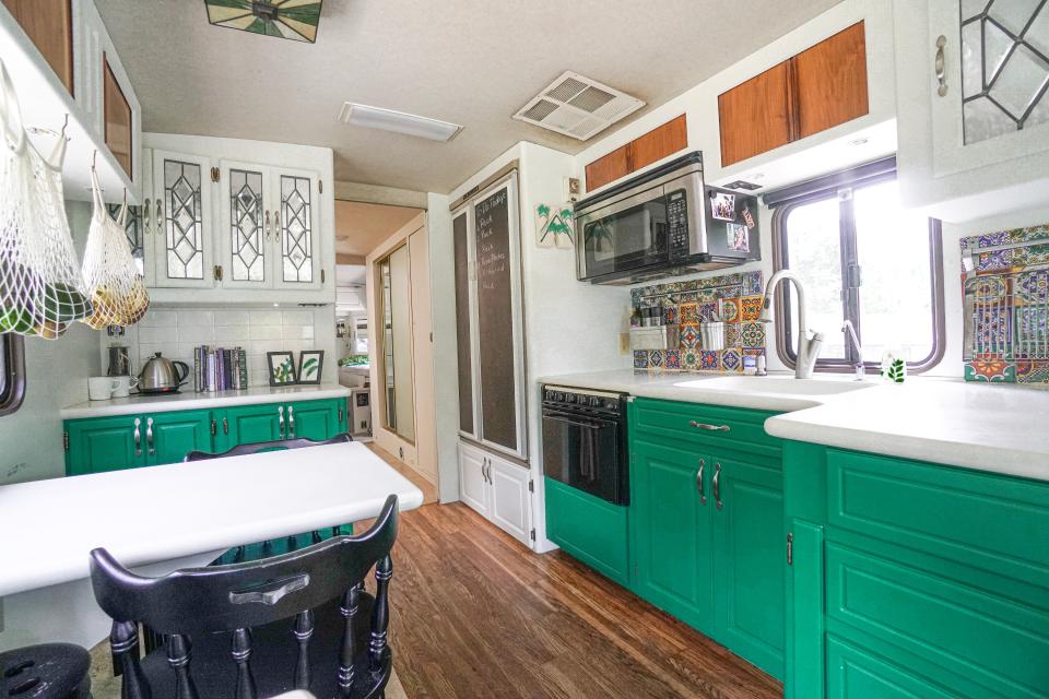 the renovated kitchen with green cabinetry in walker family RV