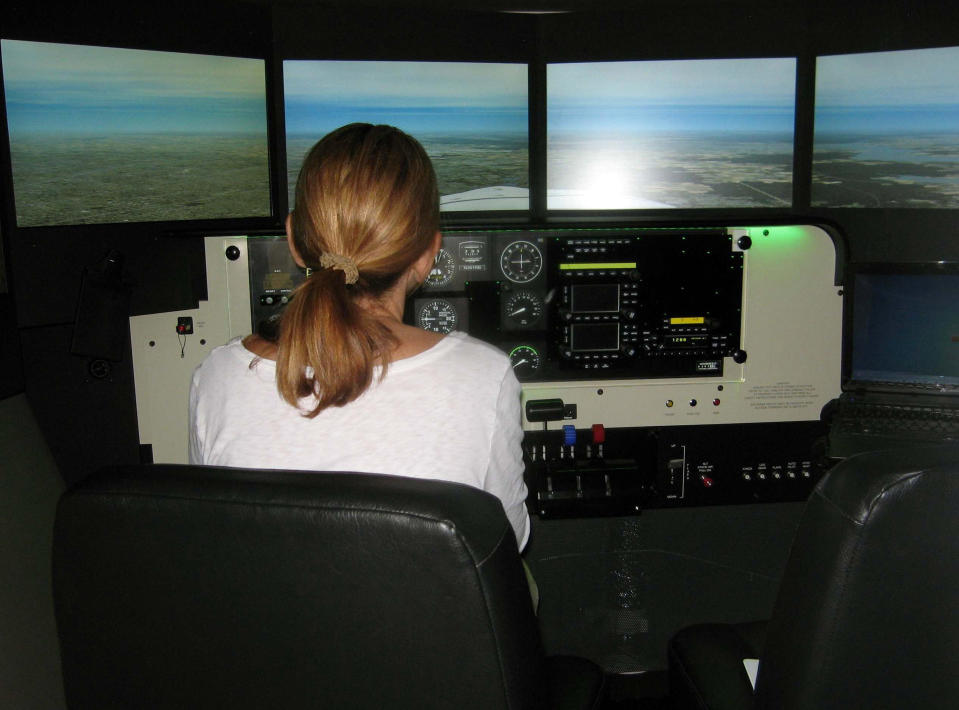 This 2012 photo supplied by the Menninger Clinic shows a woman using a flight simulator. The Menninger Clinic in Houston uses flight simulators in conjunction with cognitive behavioral therapy to help patients overcome fear of flying. (AP Photo/The Menninger Clinic, Douglas David Boyd)