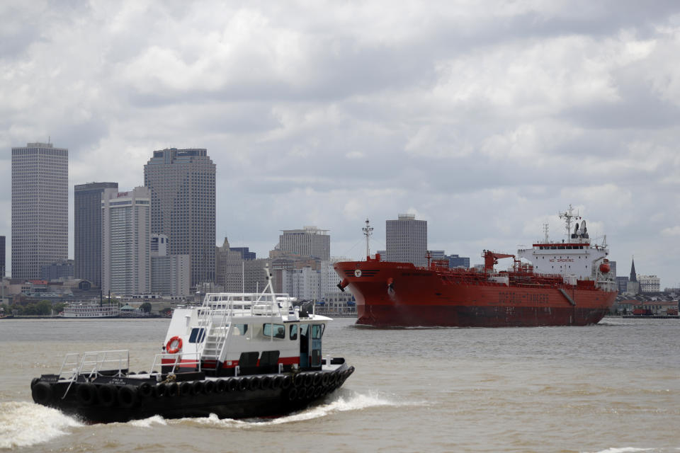 The oil tanker Bow Performer navigates a turn in the Mississippi River in New Orleans, Wednesday, May 13, 2020. Attempts to curb the spread of COVID-19 have visited a kind of triple economic whammy on the state. As oil prices have plummeted, the industry laid off workers. Tourism has dried up, meaning more lost jobs. And one major tourist draw — cuisine built around fin fish, shrimp, oyster and crabs — is also suffering. (AP Photo/Gerald Herbert)