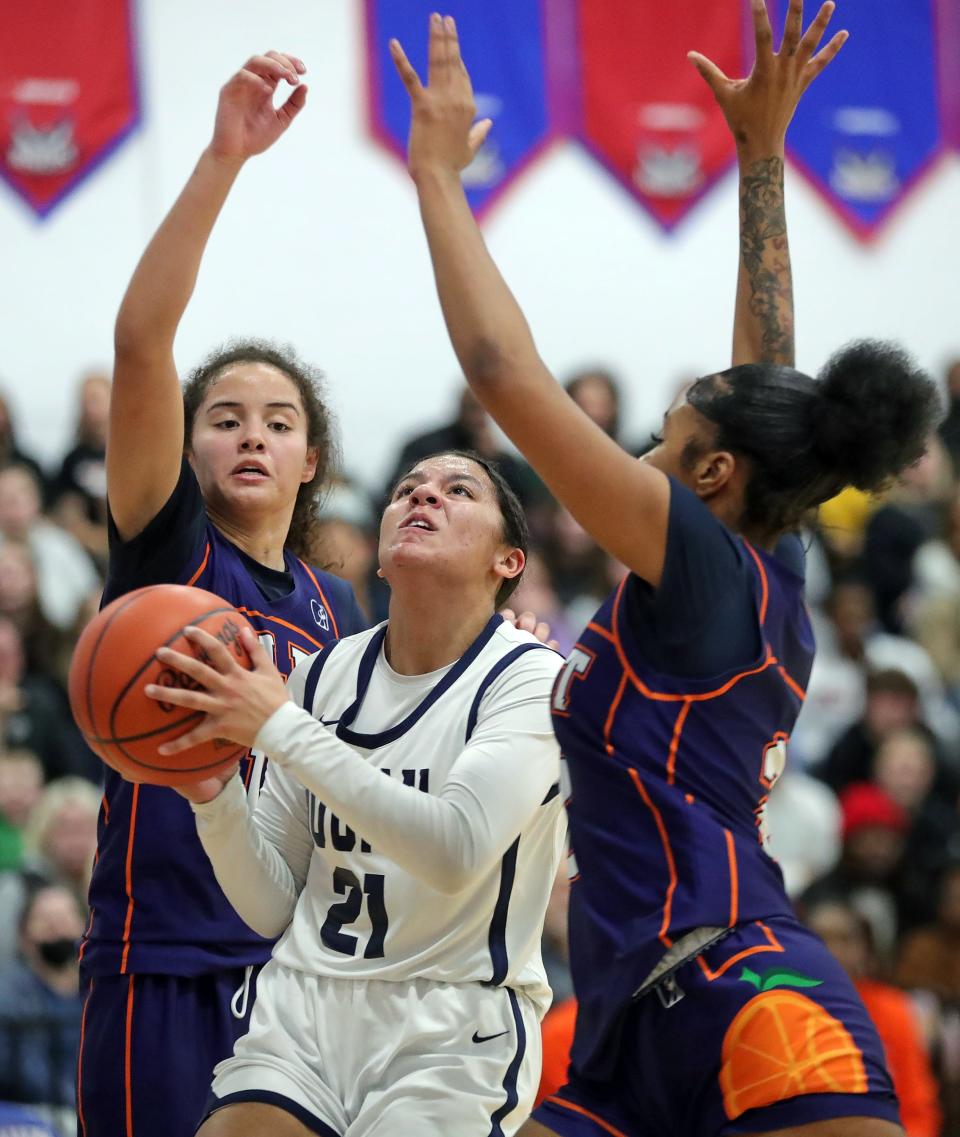 Hoban guard Zoey Hodge shoots between Ellet's Caitlyn Holmes, left, and Daci Singletary in a Division I district semifinal, Tuesday, Feb. 27, 2024, in Ravenna.