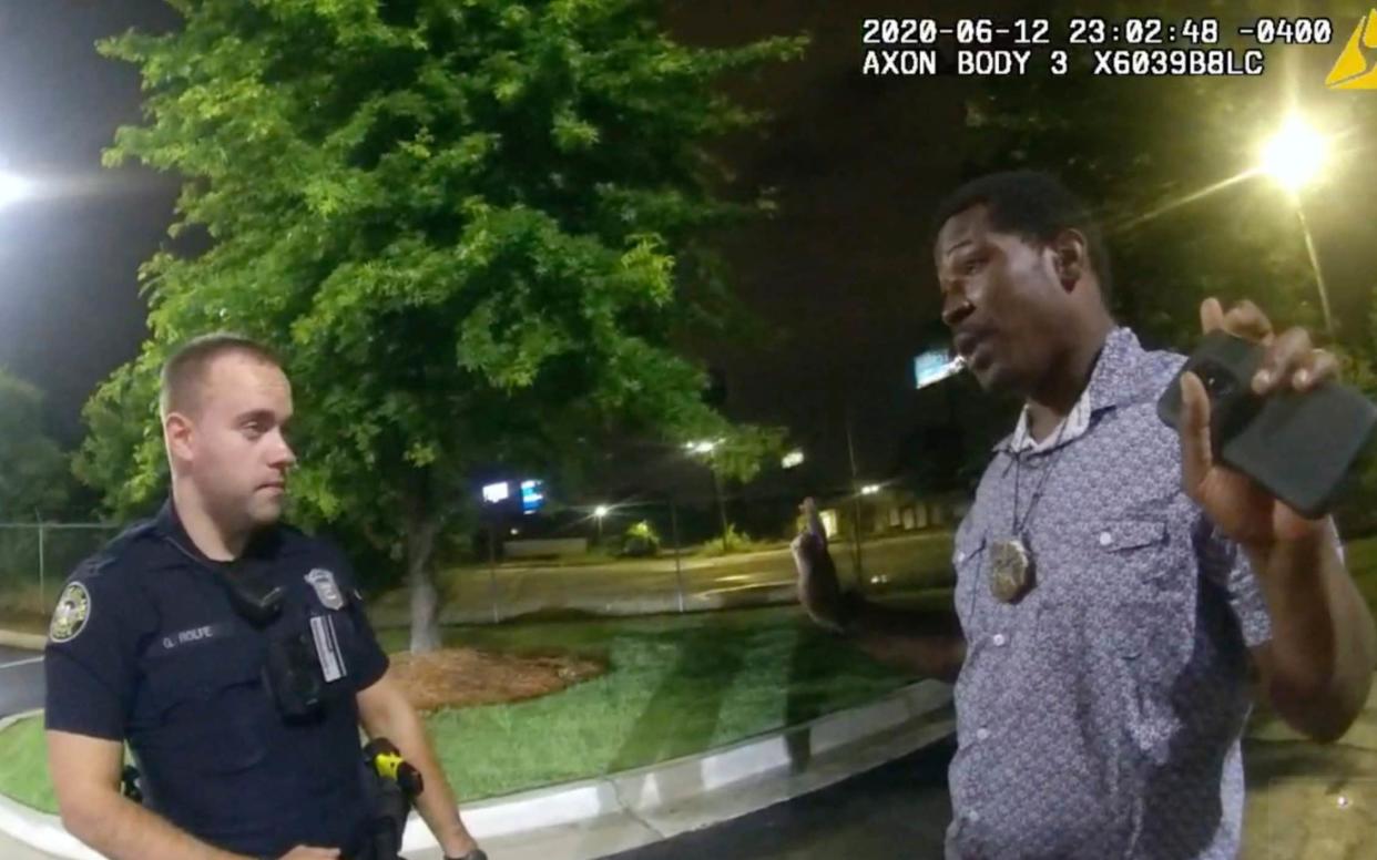 Body camera video provided by the Atlanta Police Department shows Rayshard Brooks speaking with Officer Garrett Rolfe in the parking lot of a Wendy's restaurant, in Atlanta.  - AP