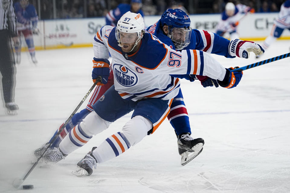 Edmonton Oilers center Connor McDavid (97) fends off New York Rangers center Barclay Goodrow during the first period of an NHL hockey game in New York, Friday, Dec. 22, 2023. (AP Photo/Peter K. Afriyie)