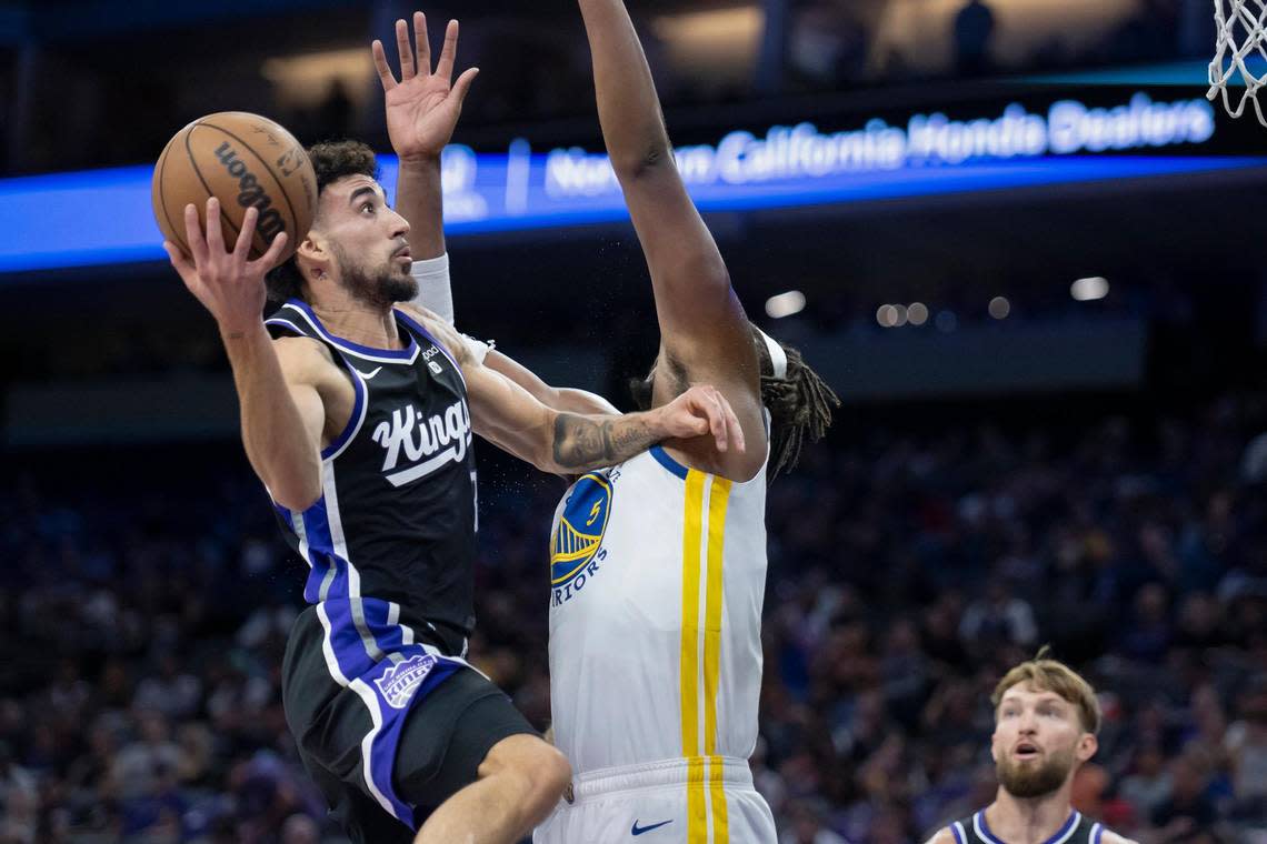 Sacramento Kings guard Chris Duarte (3) goes up for a layup over Golden State Warriors forward Kevon Looney (5) in the first half of the preseason NBA basketball game on Sunday, Oct. 15, 2023, at Golden 1 Center.