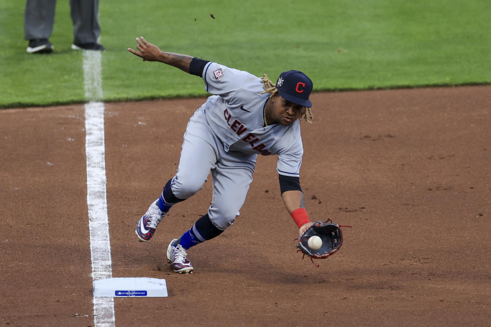 Cleveland Indians' Jose Ramirez fields the ball before throwing out Cincinnati Reds' Nick Senzel at first base during the second inning of a baseball game in Cincinnati, Friday, April 16, 2021. (AP Photo/Aaron Doster)