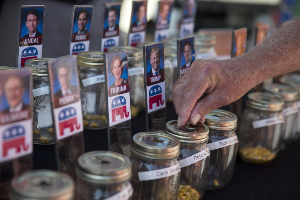 <p>An attendee places a corn kernel into a jar to vote for Donald Trump in a television news station's "Cast Your Kernel" voting booth.</p>