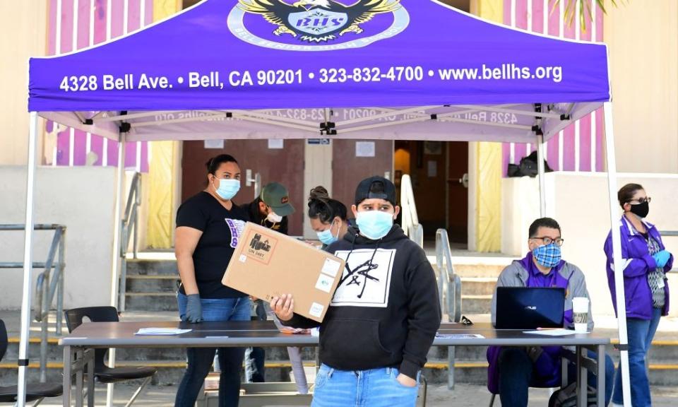 April 15: A student receives his laptop computer for remote learning in front of Bell High School in Bell, California. (Getty Images)