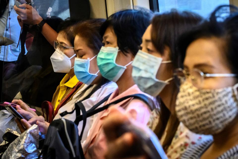 Commuters wearing facemasks amid fears of the spread of the COVID-19 novel coronavirus ride a train in Bangkok on March 9, 2020. (Photo by Mladen ANTONOV / AFP) (Photo by MLADEN ANTONOV/AFP via Getty Images)