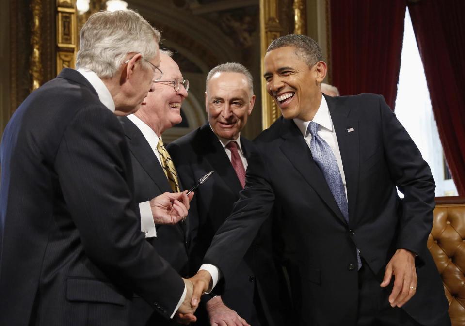 President Barack Obama laughs with, from left, Senate Majority Leader Harry Reid of Nev., Sen. Lamar Alexander, R-Tenn., and Sen. Charles Schumer, D-N.Y., on Capitol Hill in Washington, Monday, Jan. 21, 2013, after signing a proclamation to commemorate his inauguration, entitled a National Day of Hope and Resolve, following his ceremonial swearing-in ceremony during the 57th Presidential Inauguration. (AP Photo/Jonathan Ernst, Pool)