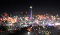 <p>Fireworks explode around National Monument during New Year celebration in Jakarta, Indonesia, January 1, 2018. (Photo: Wahyu Putro/Reuters) </p>