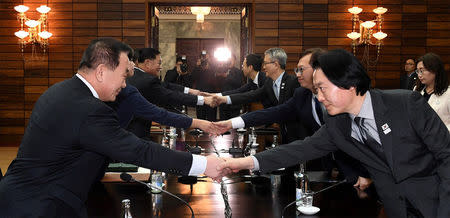 South and North Korean delegation shake hands during their meeting at Tongilgak, the North's building in the truce village of Panmunjom, North Korea, January 15, 2018. The Unification Ministry/Yonhap via REUTERS/Files