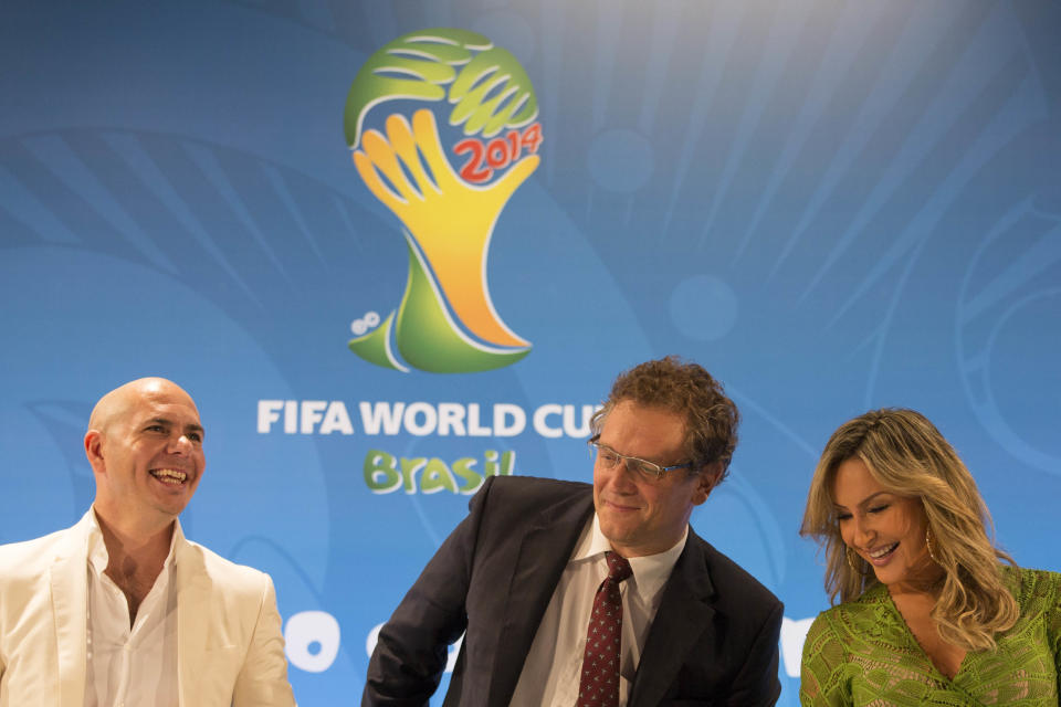 Brazilian singer Claudia Leitte, right, FIFA Secretary General Jerome Valcke, center, and rapper Pitbull react during a news conference at the Maracana stadium in Rio de Janeiro, Brazil, Thursday, Jan. 23, 2014. Claudia Leitte and Pitbull will perform with Jennifer Lopez the official song for the 2014 World Cup. Football's governing body didn't elaborate when the song, written and co-produced by Pitbull will be released. (AP Photo/Felipe Dana)