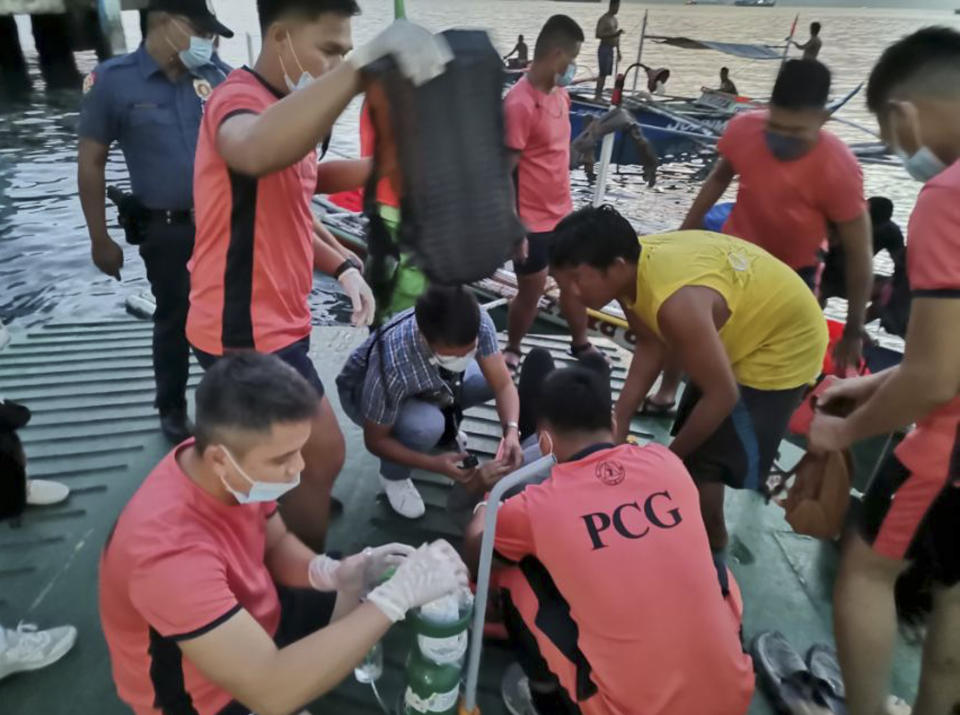 In this handout photo provided by the Philippine Coast Guard, rescuers assist a passenger of the M/V Asia Philippines, an inter-island cargo and passenger vessel, as it caught fire while approaching Batangas port, southern Philippines on Friday, Aug. 26, 2022. A Philippine ferry carrying 82 passengers and crew caught fire as it was approaching a port south of Manila on Friday. coast guard officials said. Most of the passengers and crew have been rescued as search operations continue. (Philippine Coast Guard via AP)