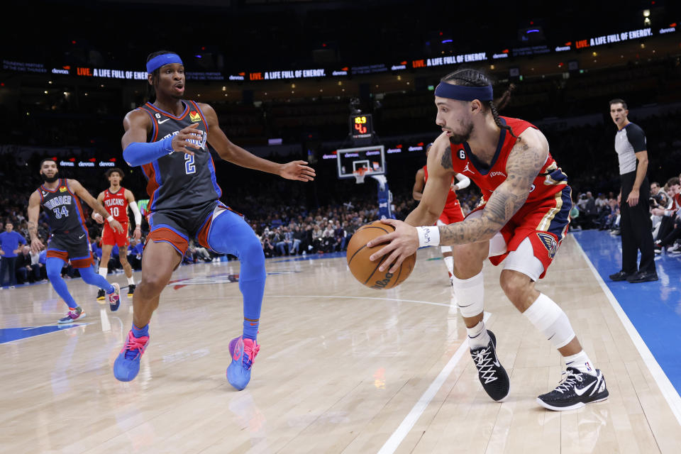 New Orleans Pelicans guard Jose Alvarado, front right, goes against Oklahoma City Thunder guard Shai Gilgeous-Alexander (2) during the second half of an NBA basketball game Friday, Dec. 23, 2022, in Oklahoma City. (AP Photo/Garett Fisbeck)