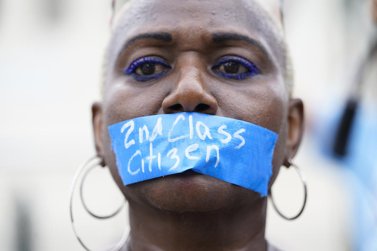 An abortion rights activist wears tape reading 