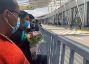 A man wearing a protective face mask holds flowers as he waits for his family at Cairo International Airport (CAI), while Egypt ramps up its efforts to slow the spread the coronavirus disease (COVID-19) in Cairo