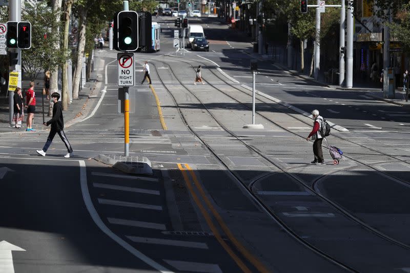 People cross a street during a workday following the implementation of stricter social-distancing and self-isolation rules to limit the spread of the coronavirus disease (COVID-19) in Sydney