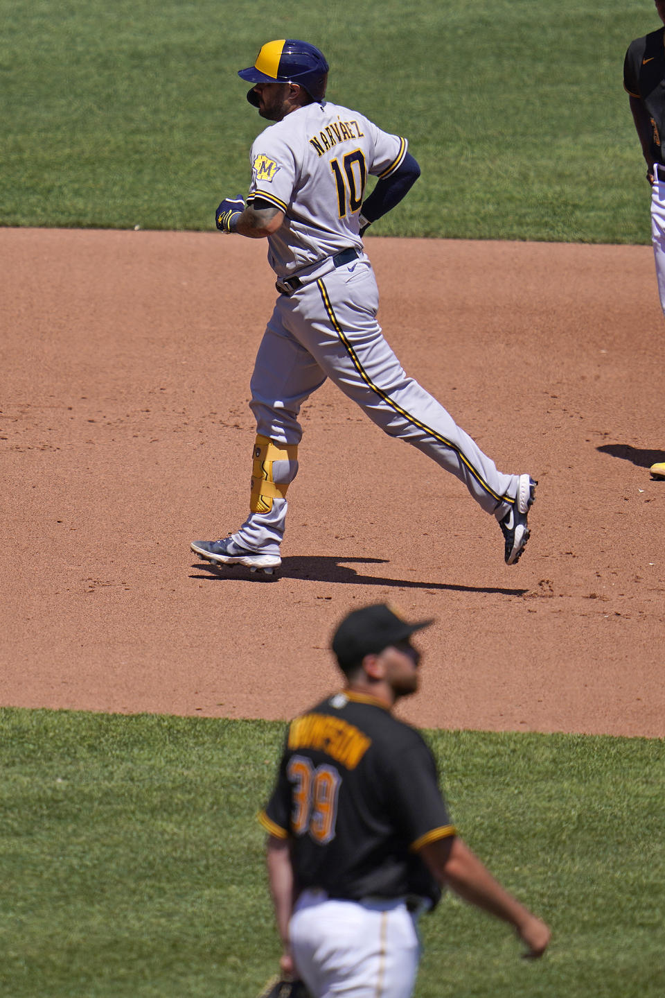 Milwaukee Brewers' Omar Narvaez (10) rounds the bases after hitting a two-run home run off Pittsburgh Pirates starting pitcher Zach Thompson, bottom, during the fifth inning of a baseball game in Pittsburgh, Sunday, July 3, 2022. (AP Photo/Gene J. Puskar)