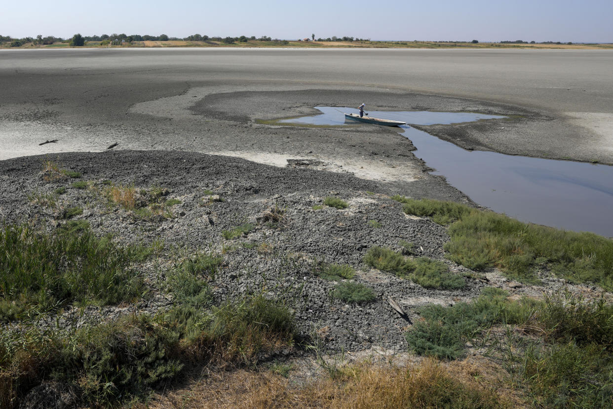 A man collects mud that is used in medical therapy at the dried out Rusanda salty lake, near Melenci, Serbia, Wednesday, Sept. 4, 2024. Experts say the summer of 2024 in the Balkans was the hottest since measurements started more than 130 years ago. (AP Photo/Darko Vojinovic)